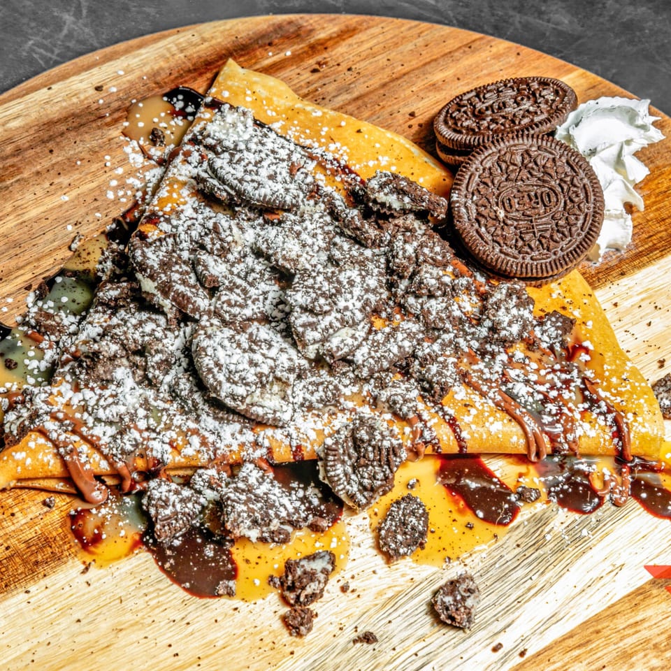 Chunky Bites' Oreo crepe, drizzled with chocolate and caramel, topped with powdered sugar and cookies.