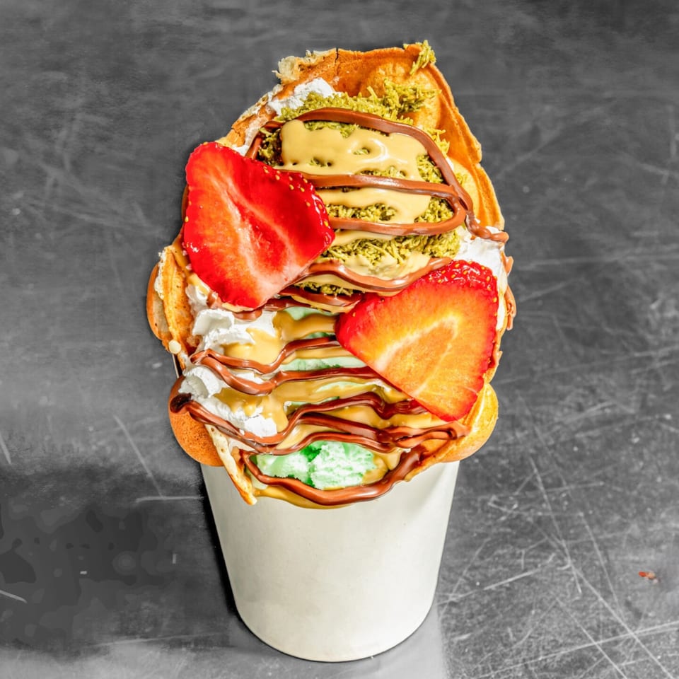 Chunky Bites' bubble waffle with strawberries, whipped cream, pistachio, and chocolate and caramel drizzle.